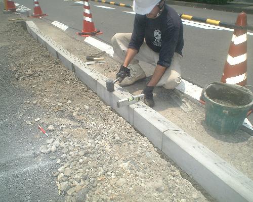 縁石を据え付ける職人の手作業