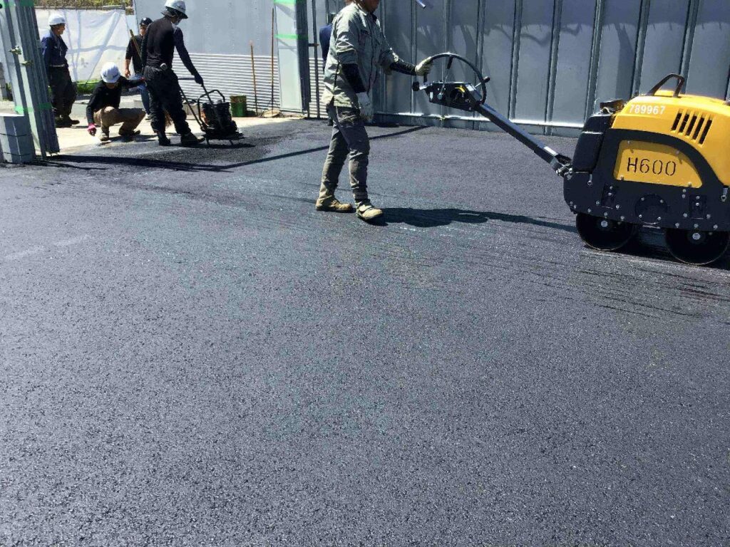 アスファルトを転圧する職人
